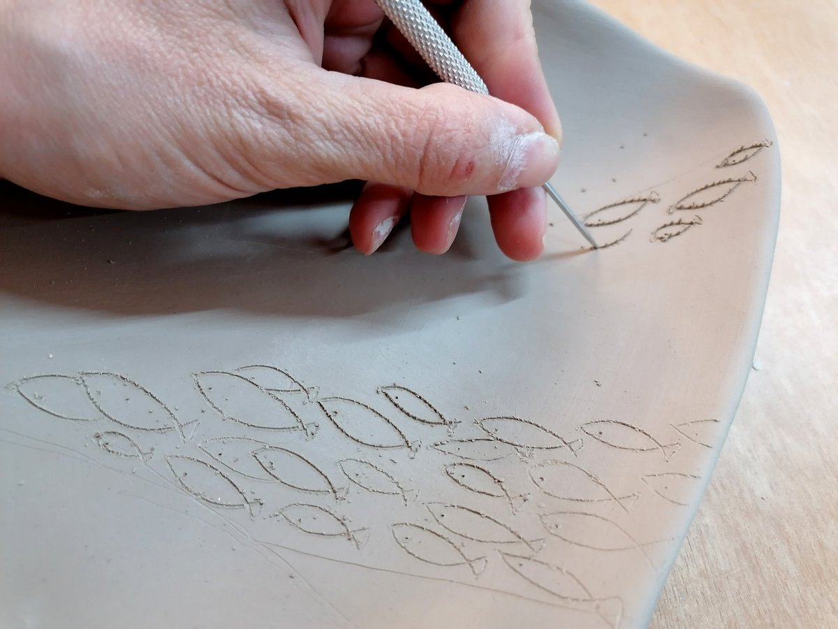 Hands at work shaping clay in the Afis Yfes Athens studio