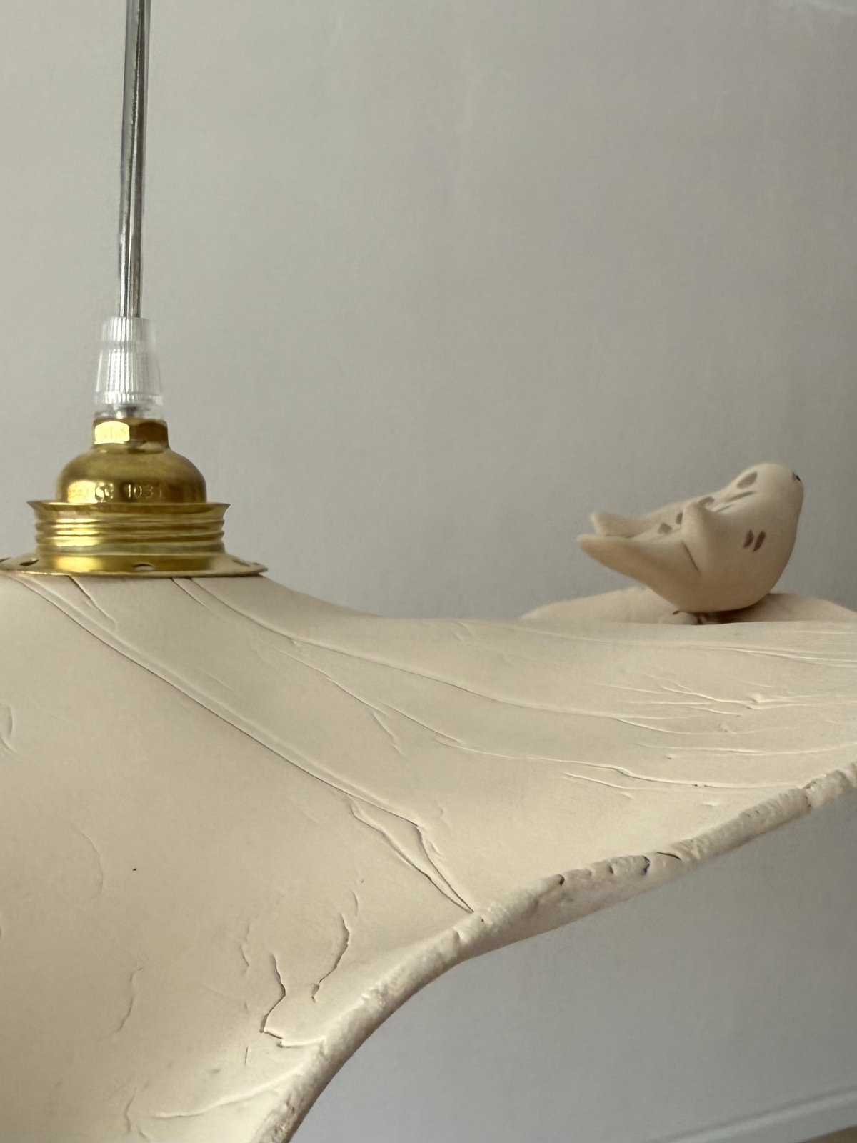 Sculpting Light &mdash; detail of the sculptural bird perched on the shade&rsquo;s edge