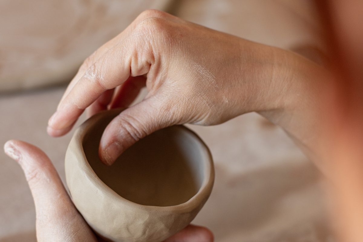 The Primordial Vessel workshop — hand-pinching clay into a small ceramic bowl